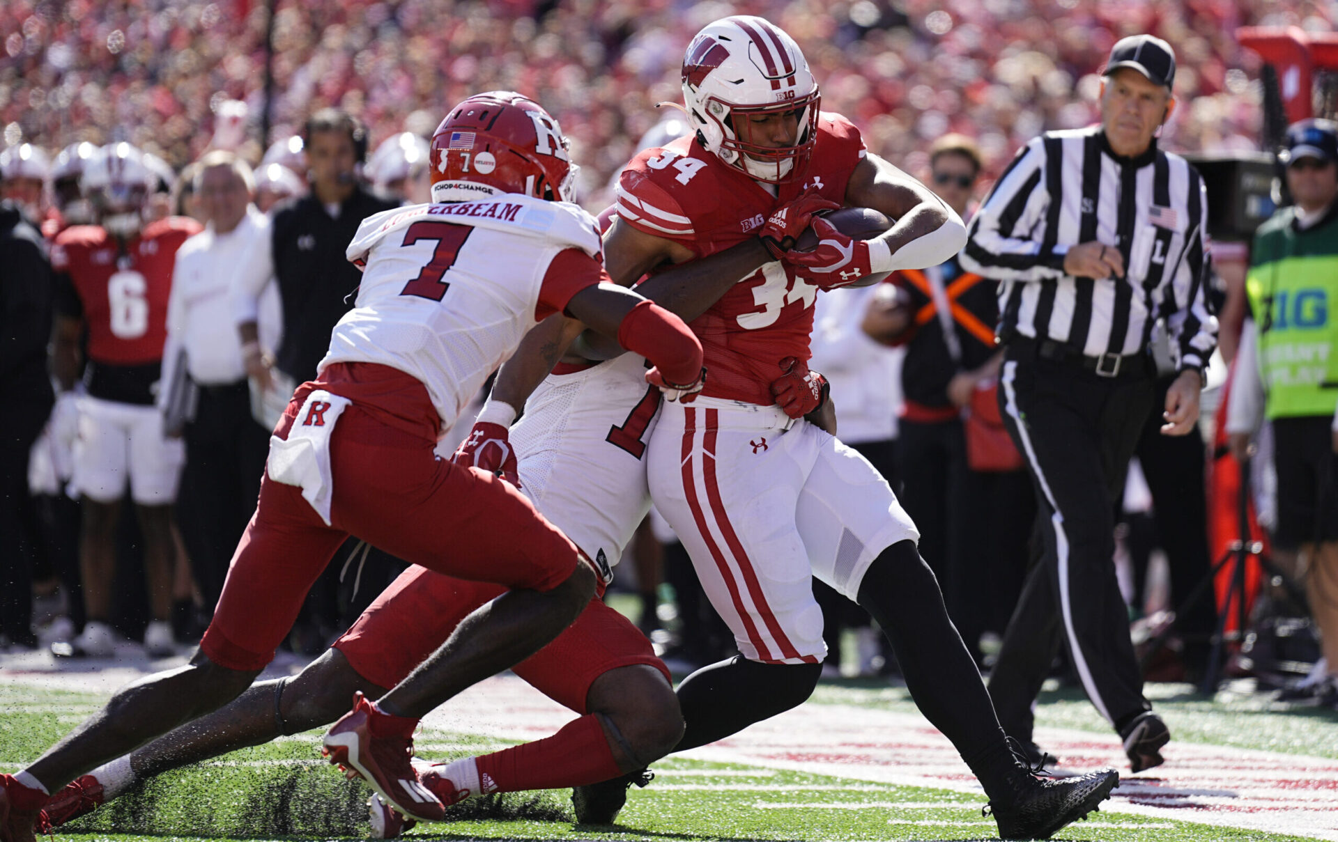 Wisconsin Badgers football running back Jackson Acker carries a pile of Rutgers defenders