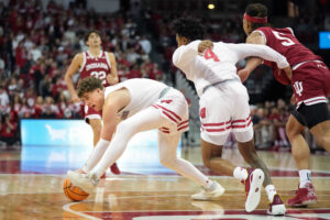 Wisconsin basketball guards Max Klesmit and Kamari McGee attempt to recover a loose ball in a game against the Indiana Hoosiers